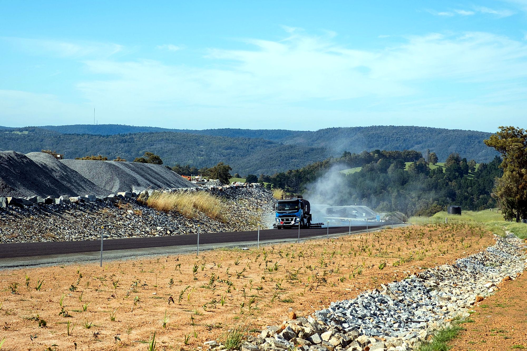 WA Sprayseal sprayer applying bitumen on a new road in the hills