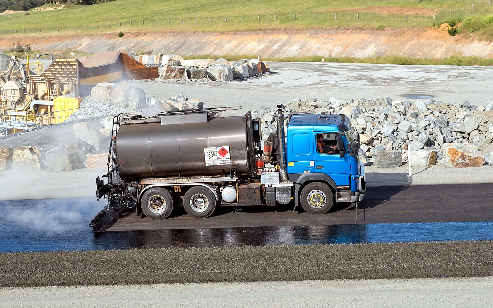 Sprayer applying hot bitumen in an even film