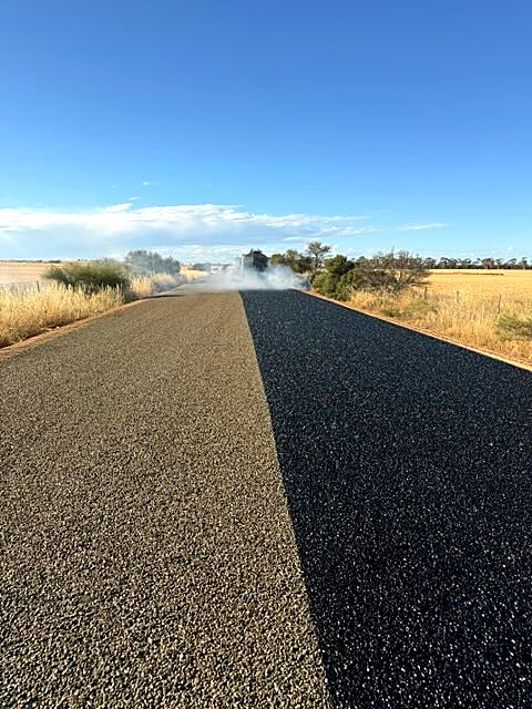 Two-coat seal on a rural road, second coat freshly applied
